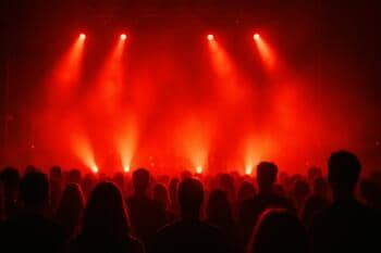 Akşam kalabalığı: sahne önünde kızıl ışıkla aydınlanan silüetler